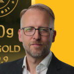 Frank Watson headshot with Kinesis gold bullion bar